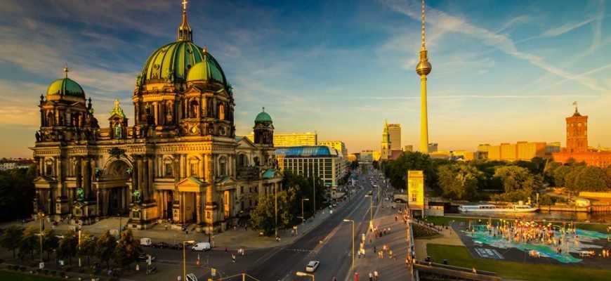 An evening scene of a city in Berlin, Germany showing temple like houses and roads with cars