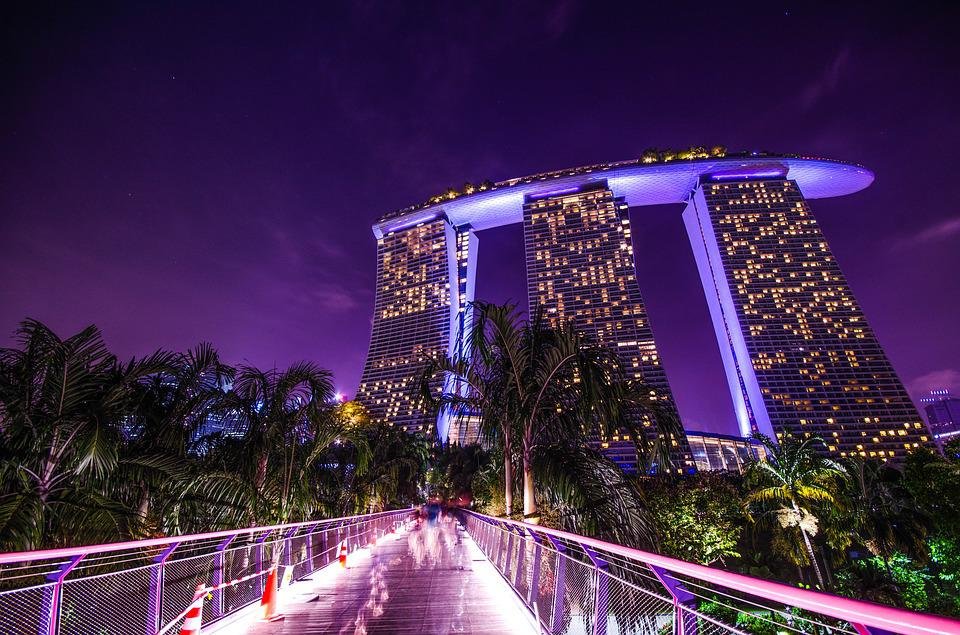 A beautiful night scene at Marina Sands Bay, Singapore with pink lights over a tall building