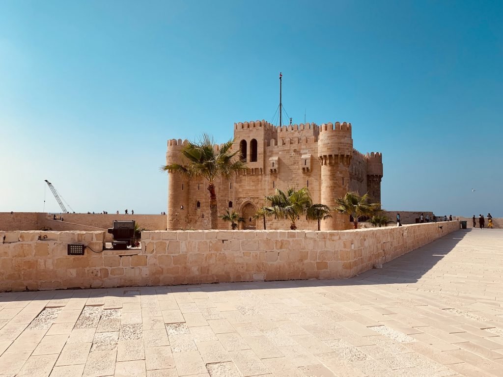 a brown fort under a blue sky and one of the most beautiful spots to tour in Egypt