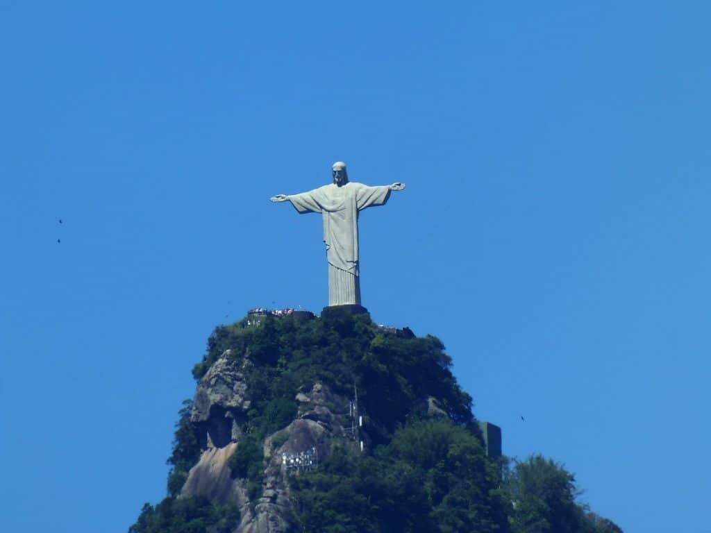 a white statue of liberty under blue sky in one of the top-rated tourist attractions in Brazil