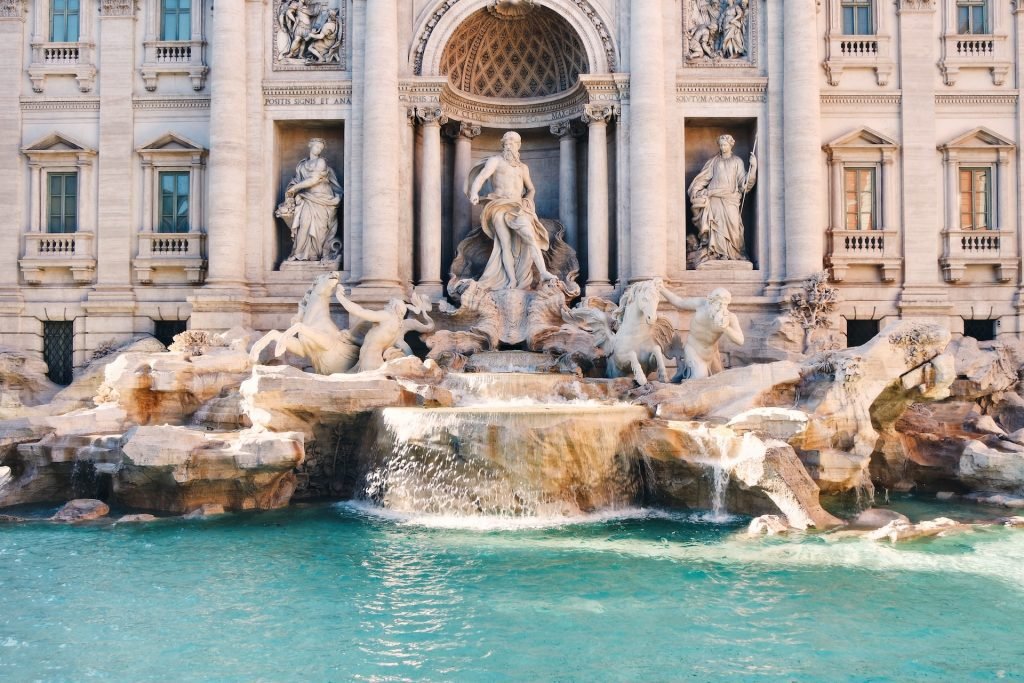 white sculptures in front of a fountain