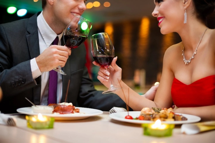 A couple with wine in their glasses smiling together during a date night