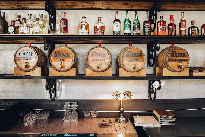 A bar shelf with drinks glasses and lights. 