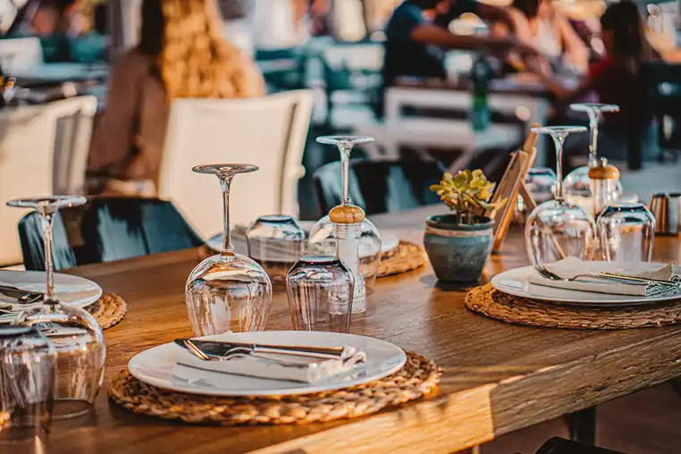 A dinner table, glasses and cutlery. 