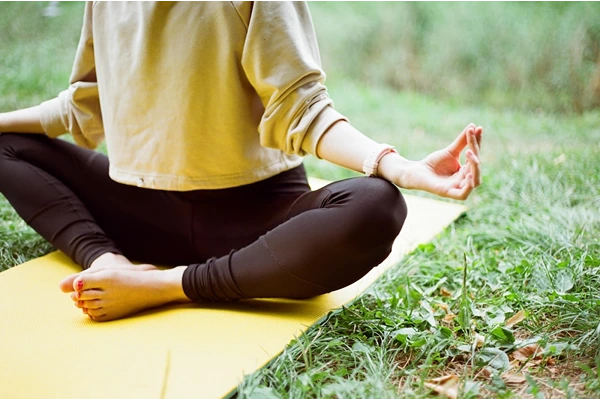 A woman doing yoga outdoors on a mat