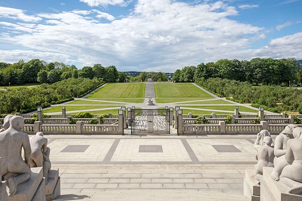 Vigeland Park with sculptures and green vegetations under a bright blue sky. 