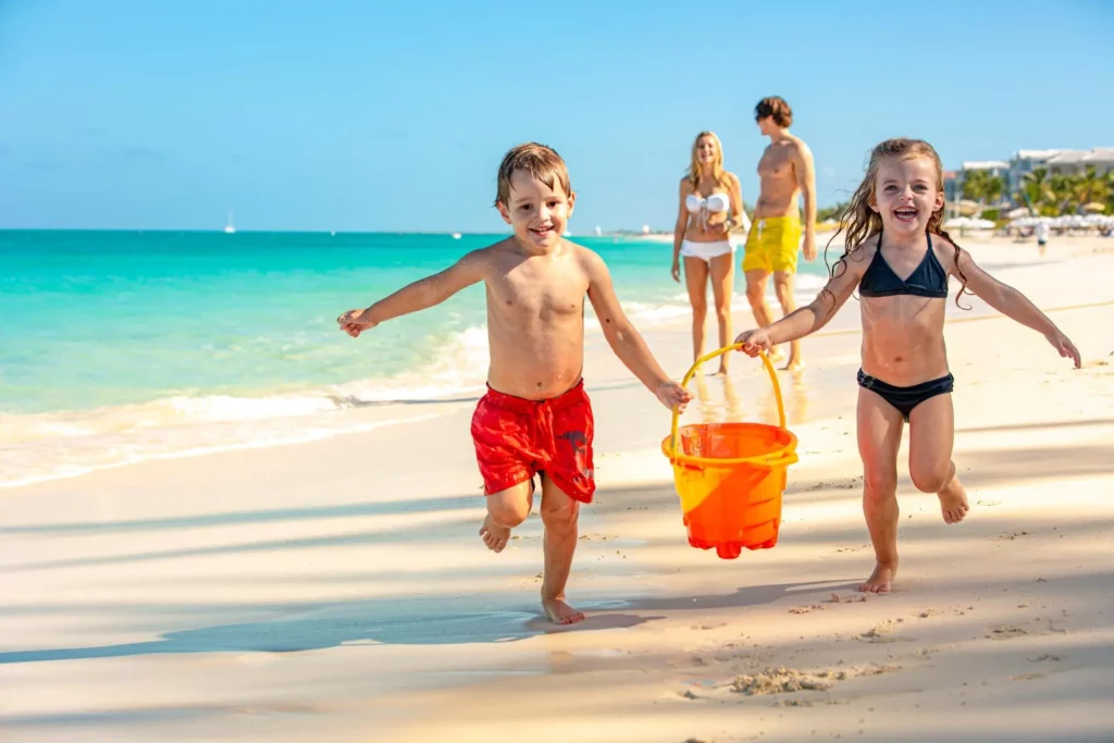 Affordable Beach Vacations for Families


Two Kids playing on a beach with a bucket, with two adults behind them