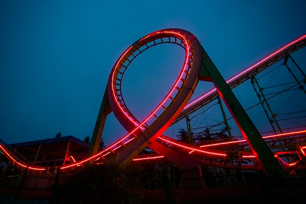 A rollercoaster at night with shining red lights