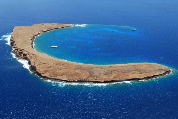 A crescent shaped Island in a clear blue water