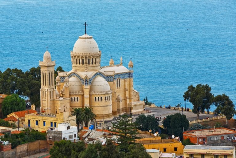 brown buildings in front of a blue lake in one of the must-visit attractions in Algiers, Algeria