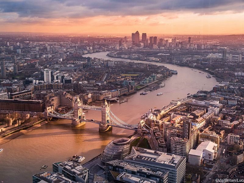 Aerial view of London in the evening showing the London bridge, skyscrapers, and a river 