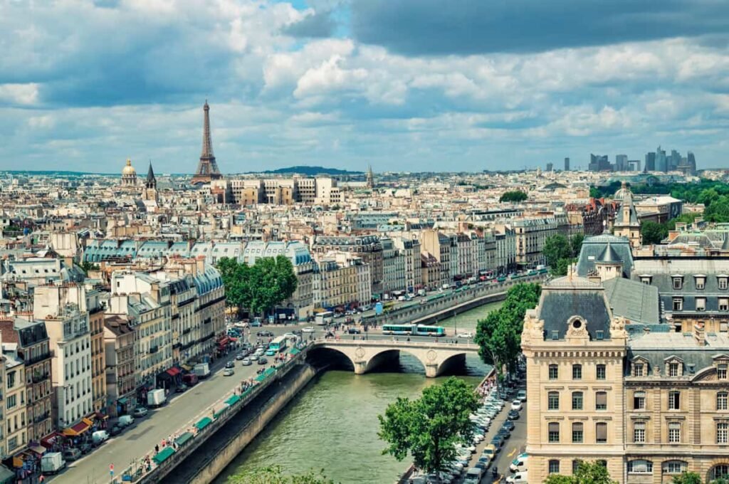 Aerial view of the city of Paris showing the Eiffel Tower, bridges, cars and people walking by the road