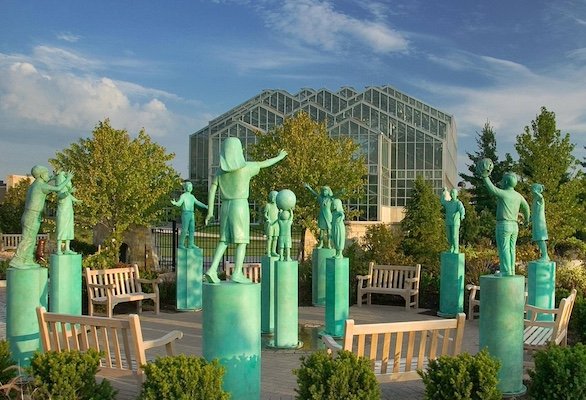 Group of green sculptures in a park in front of a museum