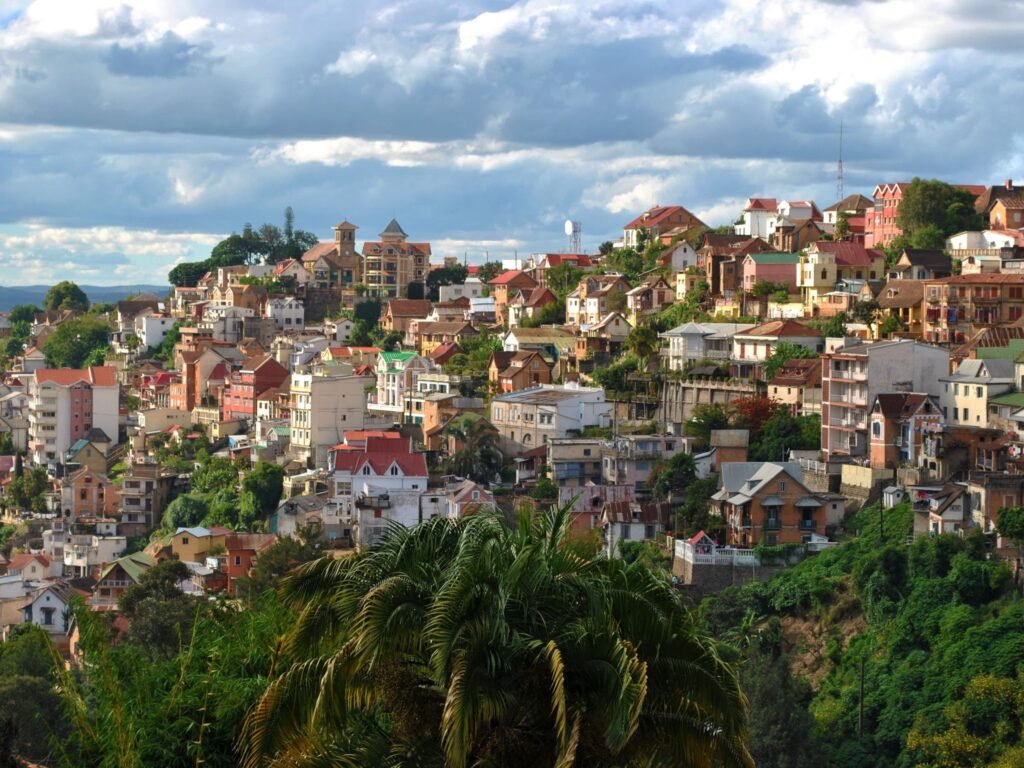 An aerial view of a city in Madagascar with lots of house and tall palm trees in between the houses